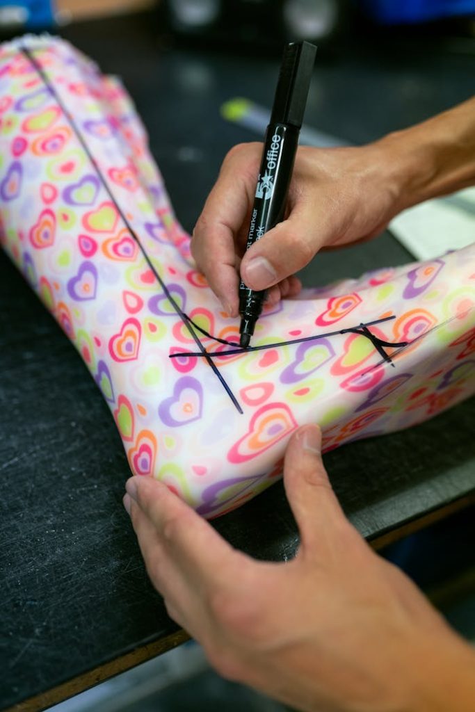 pexels photo 3913007 Orthotic technician tracing design on colorful ankle foot brace.